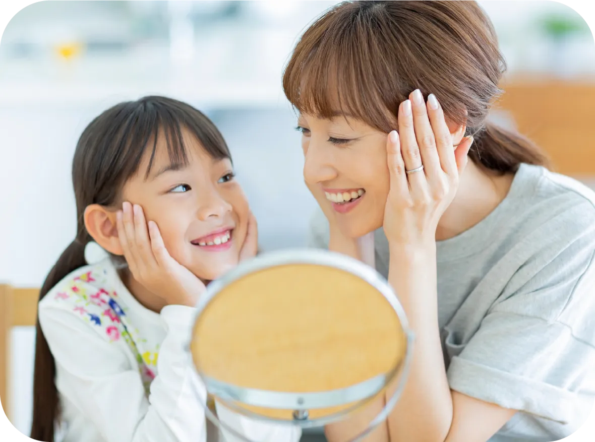 鏡を見て笑う親子